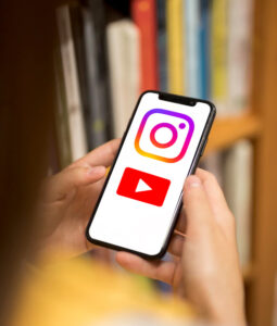 This image shows a mock-up image of an iPhone with the YouTube and Instagram logo images superimposed.